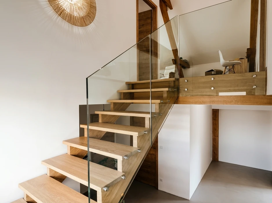 Escalier intérieur contemporain en bois de chêne clair, à marches flottantes sans contremarches, avec garde-corps en verre trempé fixé par des embouts chromés