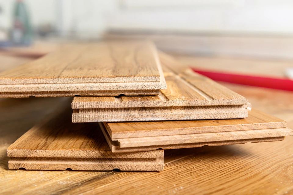 Intérieur d'atelier de menuiserie avec lames de parquet en bois naturel empilées sur établi