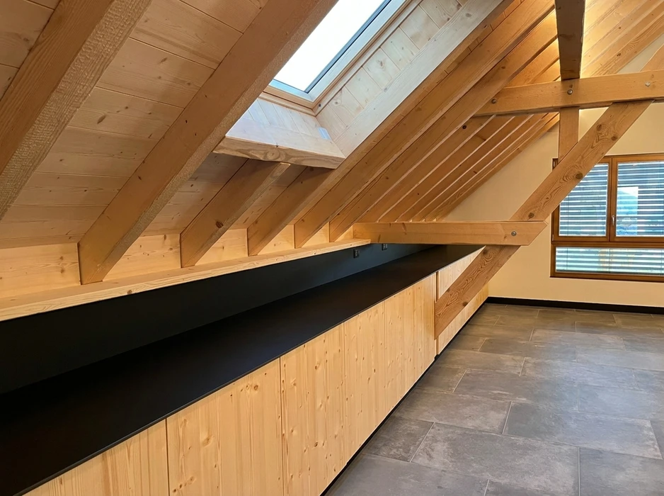Comble aménagé avec charpente apparente en bois massif résineux, poinçons et arbalétriers visibles