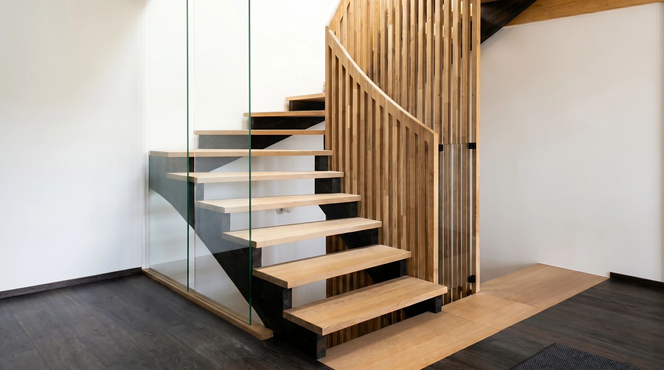 Escalier flottant en chêne massif avec garde-corps en verre feuilleté fixé par des points d'ancrage inox