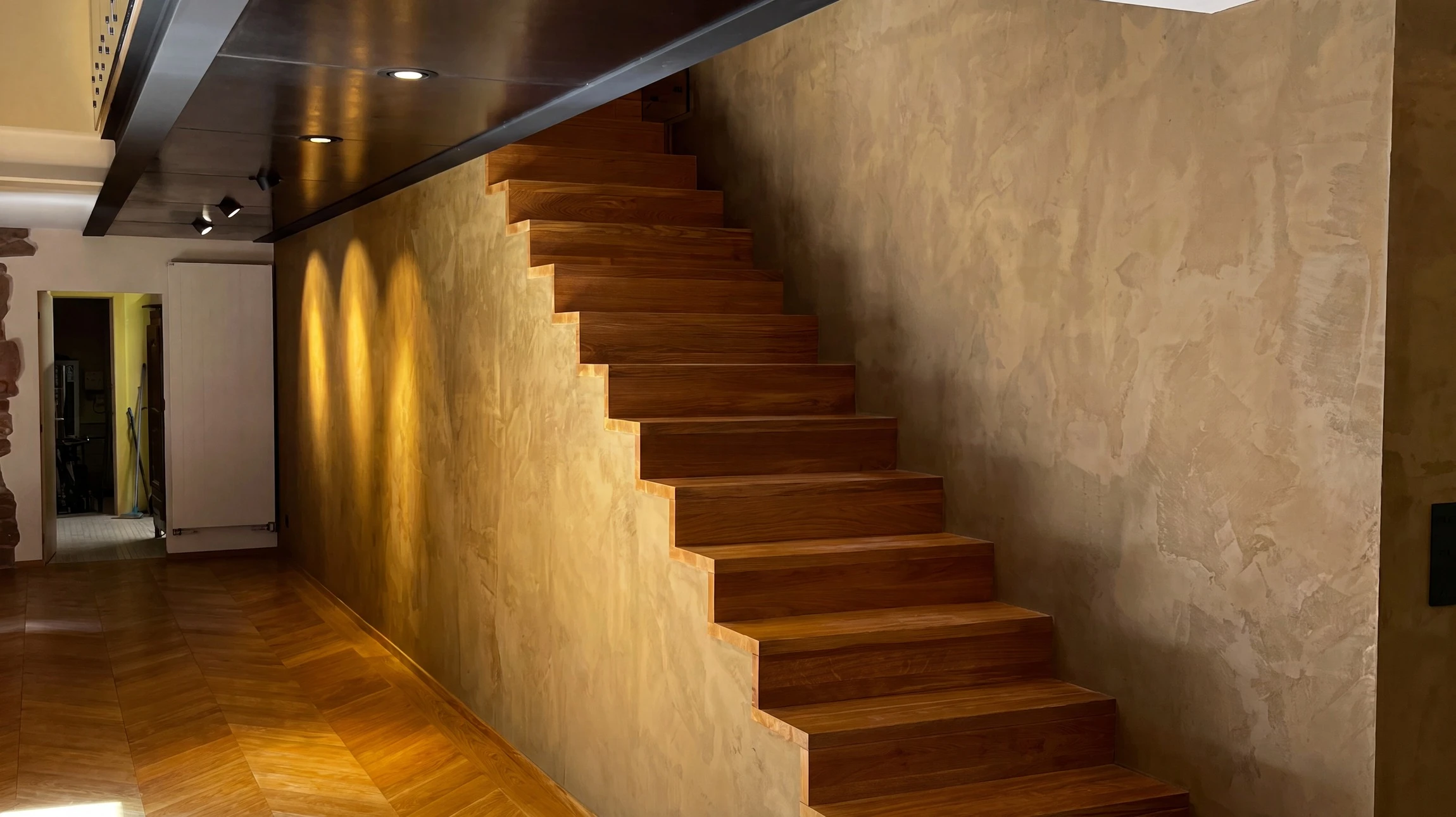 Escalier intérieur moderne avec marches en bois massif et garde-corps métallique noir