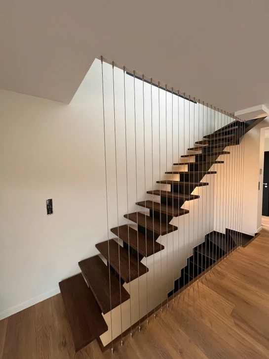 Escalier intérieur moderne avec marches en bois massif et garde-corps métallique noir
